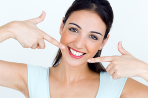 woman pointing to her beautiful smile