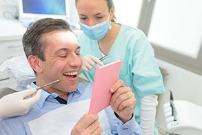 A man looking at his new dental implants