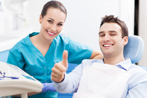 Smiling man in dental chair giving thumbs up