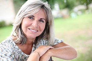 Older woman with dental implants in Salinas smiling outside