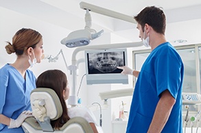 Implant dentist in Salinas pointing at an X-ray with patient