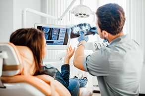 a patient and a dentist examining a dental chart