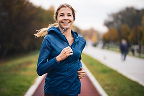 Woman smiling while running on track