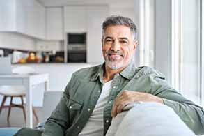 Man smiling while sitting on couch at home