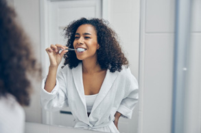 a woman brushing her teeth in a bathroom