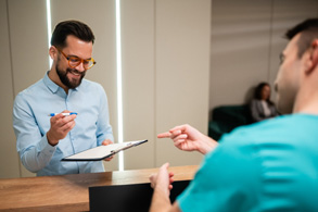 a man filling out forms on a clipboard