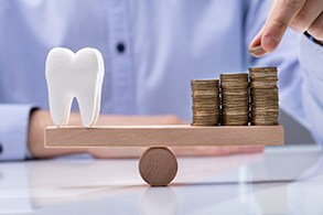Tooth model balance against stacks of coins