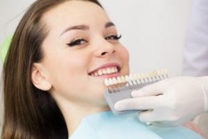 Smiling woman having her tooth shade matched