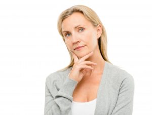 woman thinking over the dental implant cost