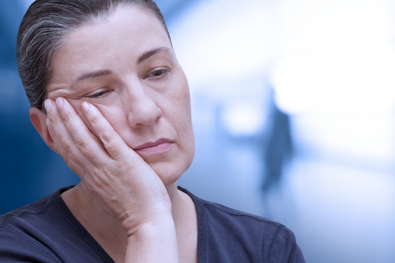 Patient holding cheek due to dry socket