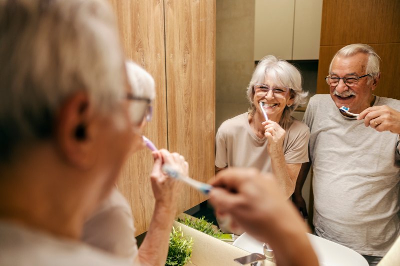 Older patients smiling while performing dental hygiene